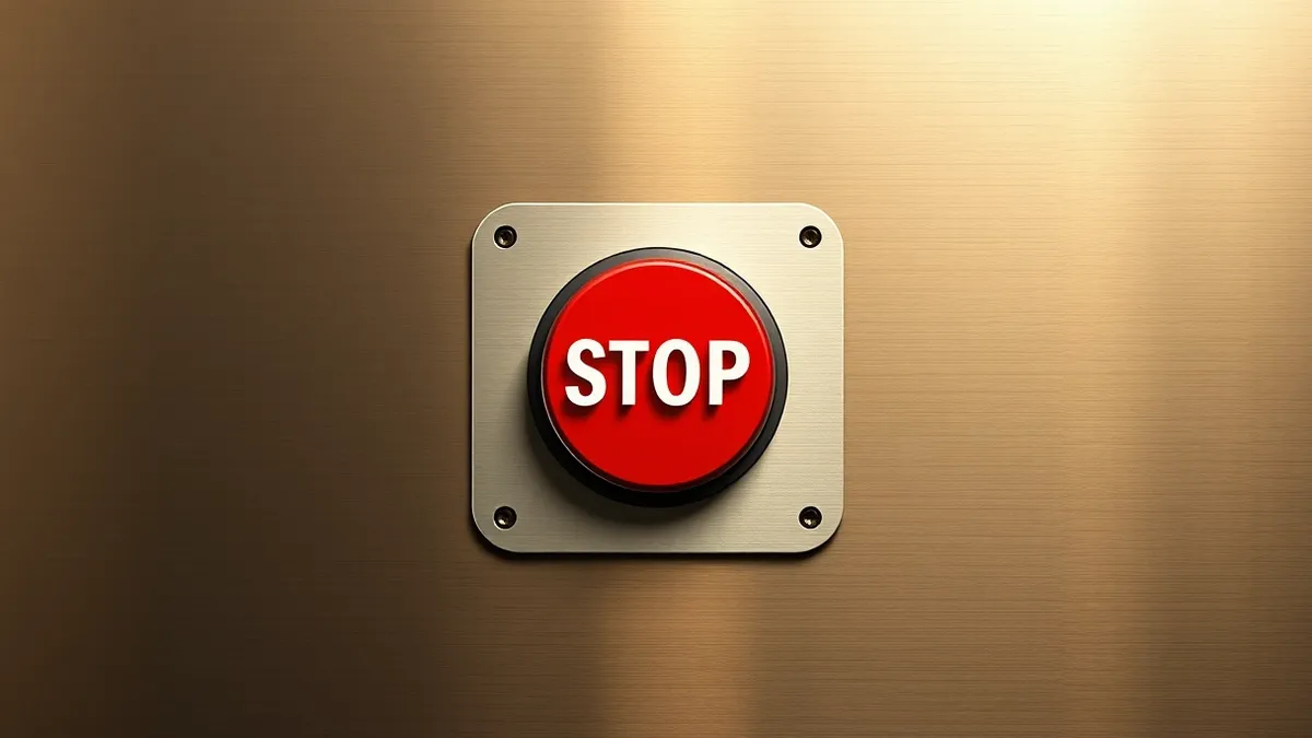 Illustration: A sleek, red emergency stop button sits mounted on a brushed metal control panel.